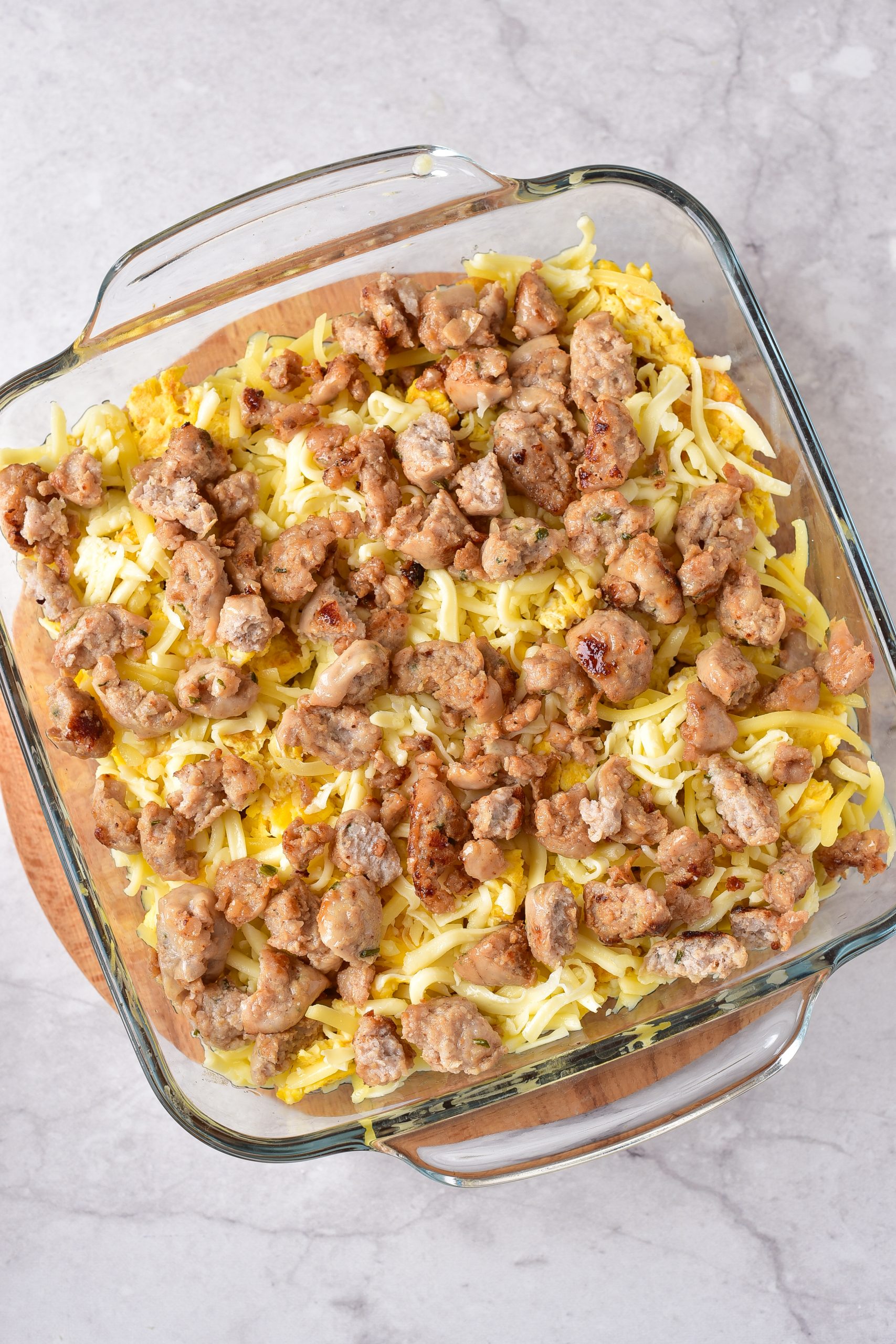 Top with scrambled eggs, sausage and cheese. 