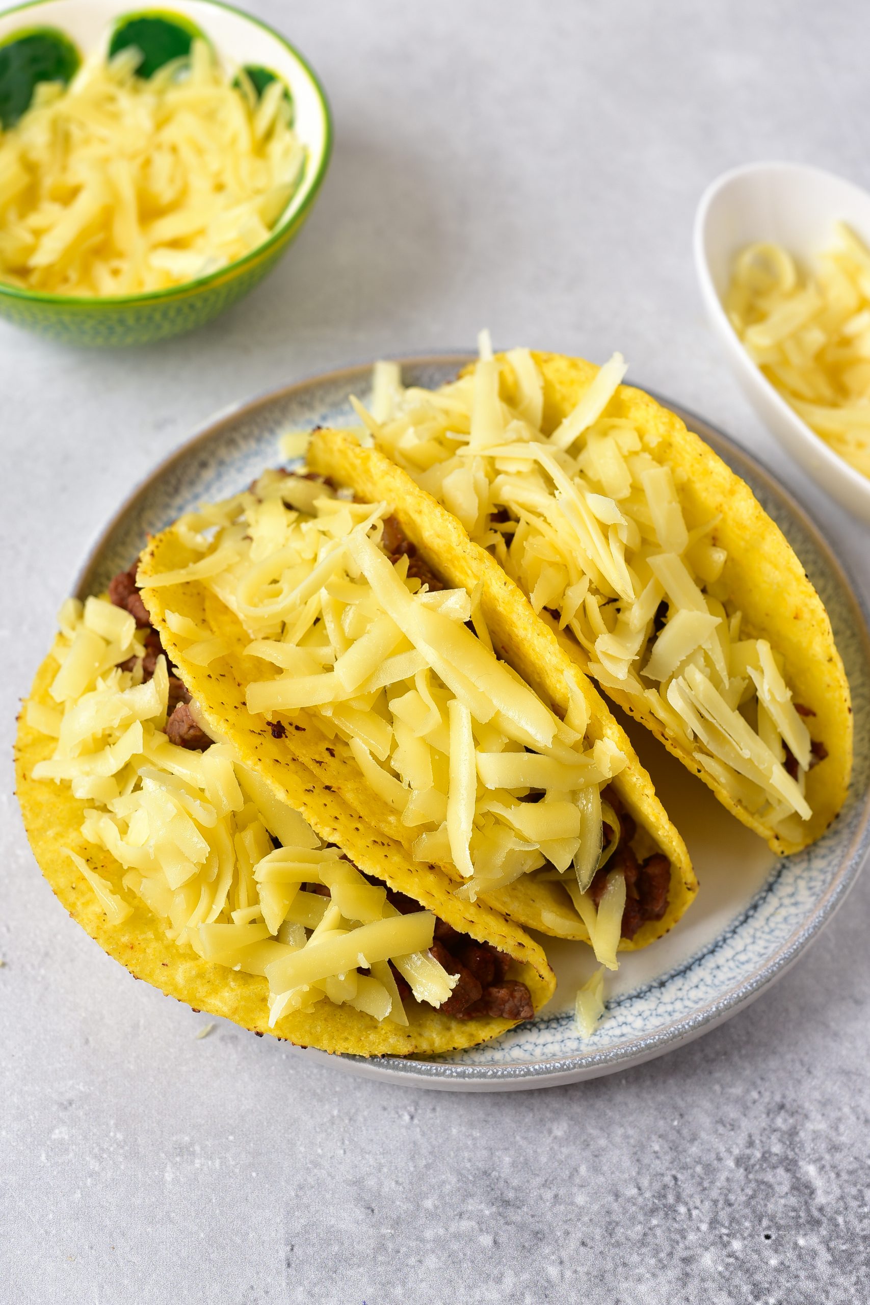Layer the meat in the taco shells, and top with the shredded cheese. Bake for about 5-10 minutes, or until the cheese melts.