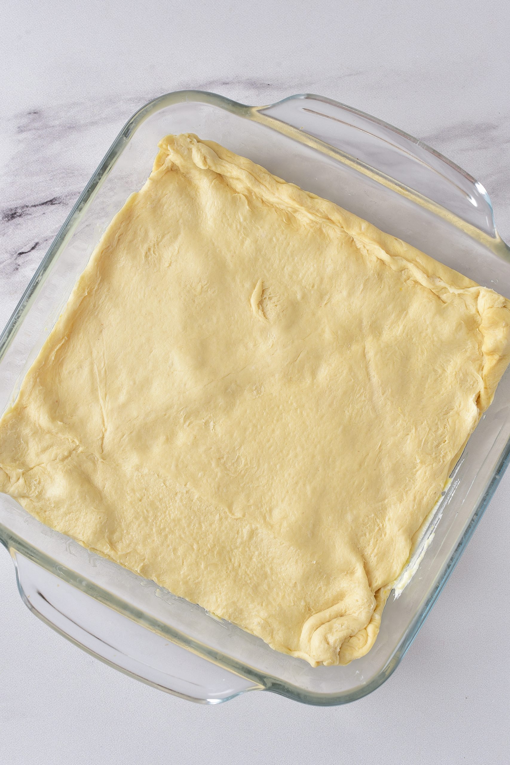 Top the filling with the remaining layer of dough