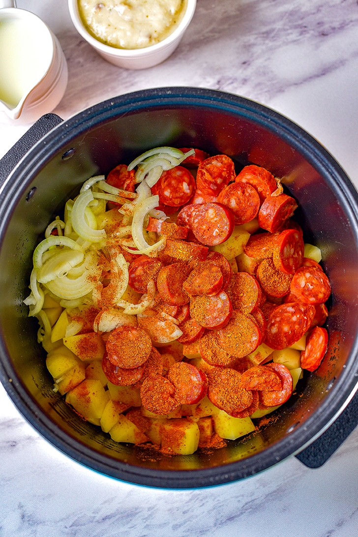 Mix together the sausage, potatoes, and onions in the bottom of the Crockpot.