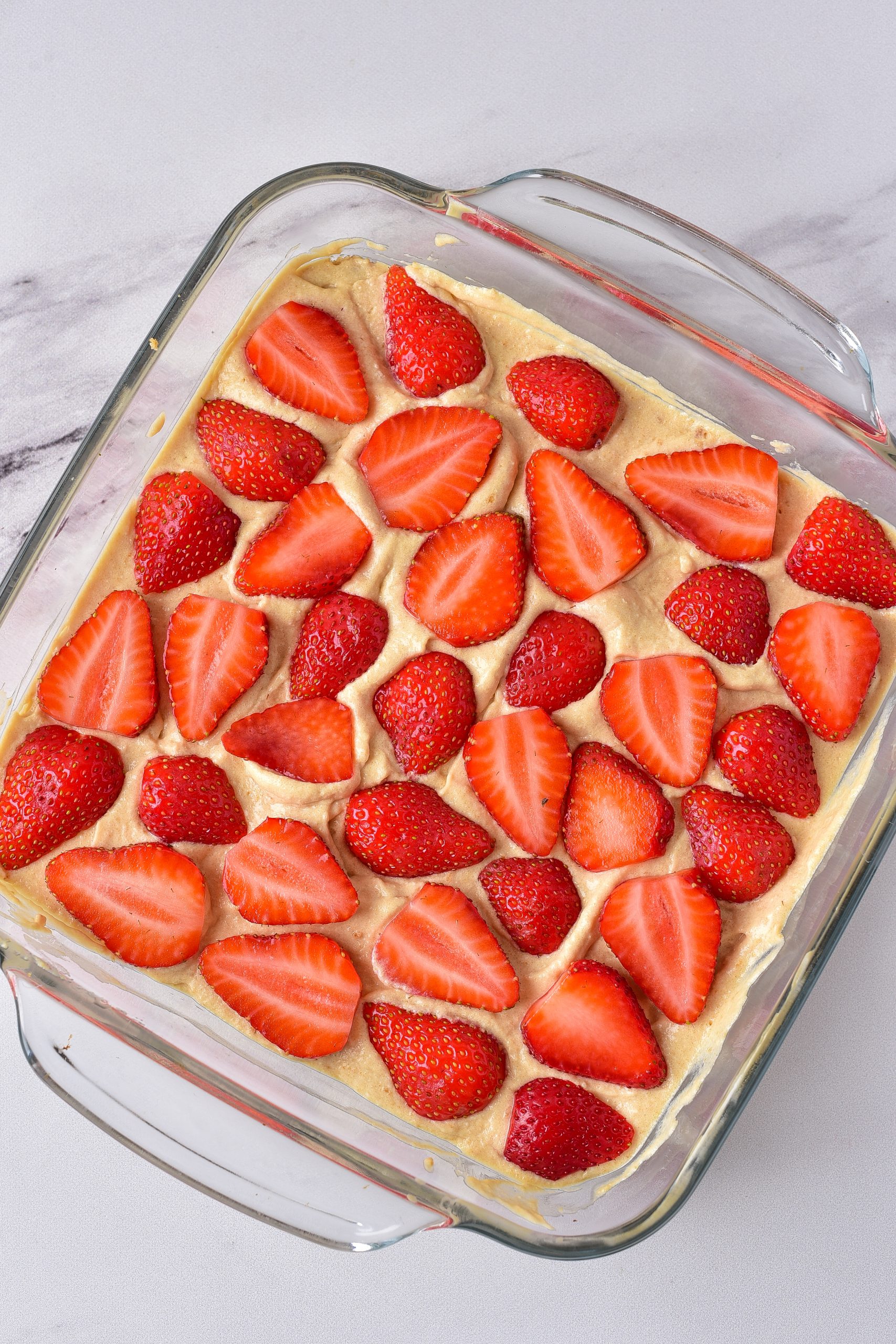 Top the cheesecake layer with half of the strawberry slices. 