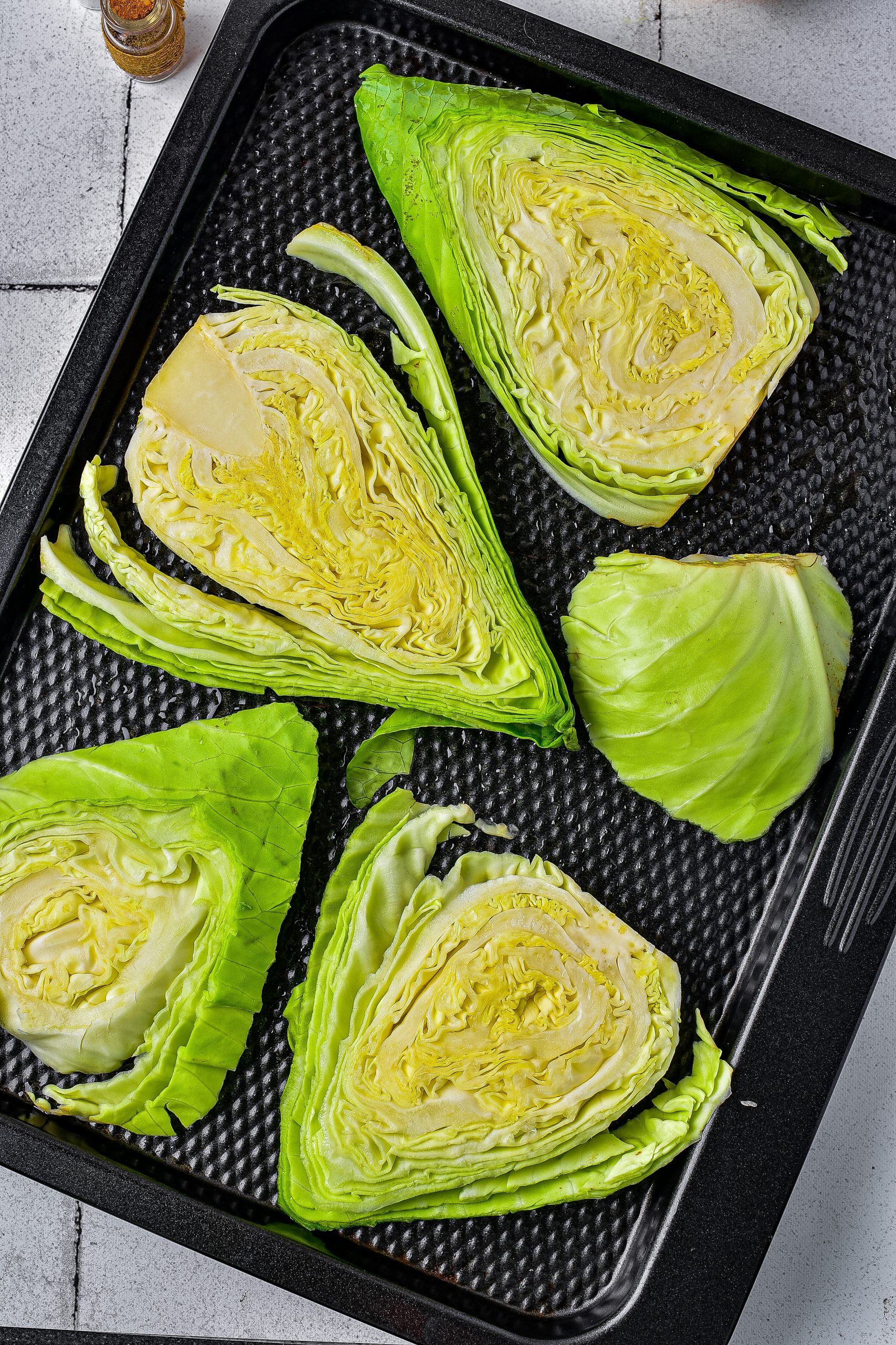 Place the cabbage steaks onto the baking sheet, and drizzle with olive oil
