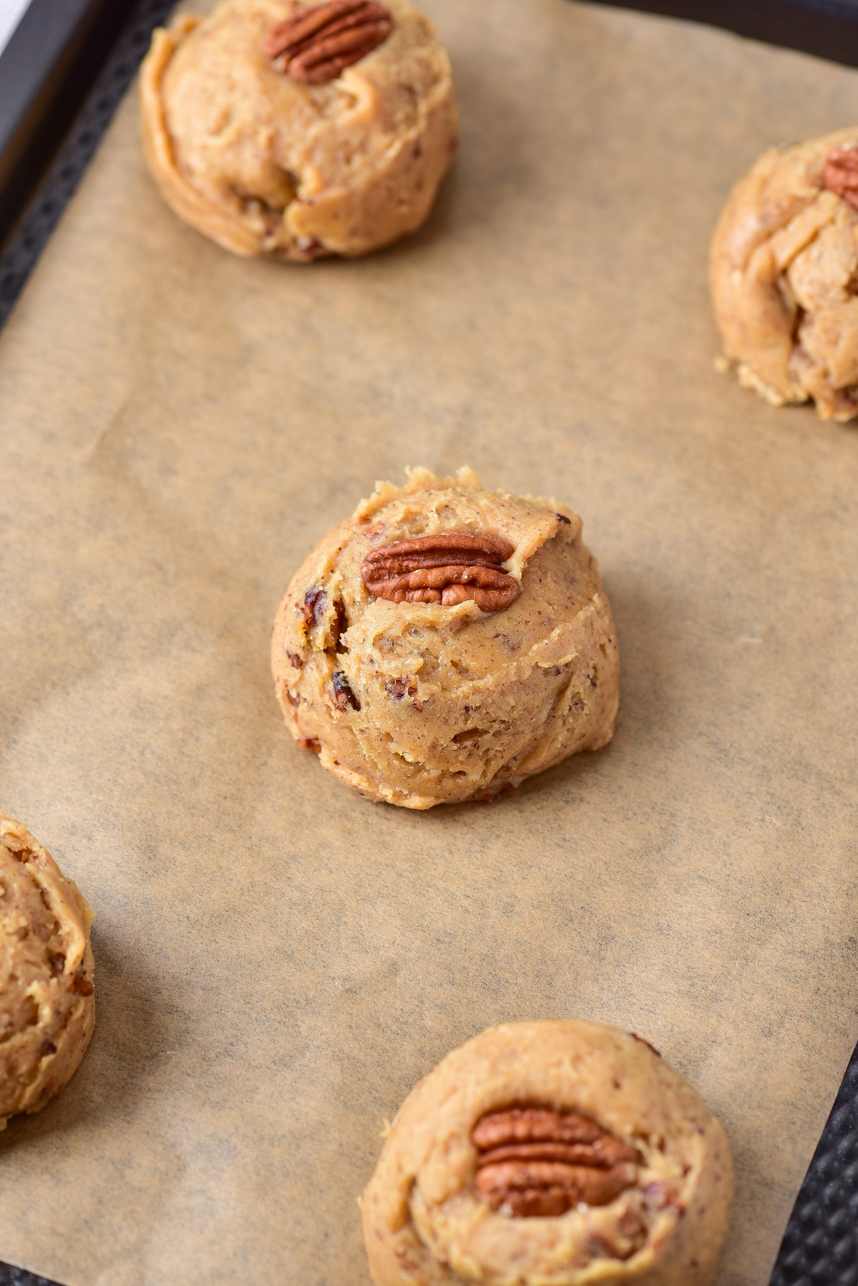 Flatten the cookies slightly, and place a pecan half in the center of each one