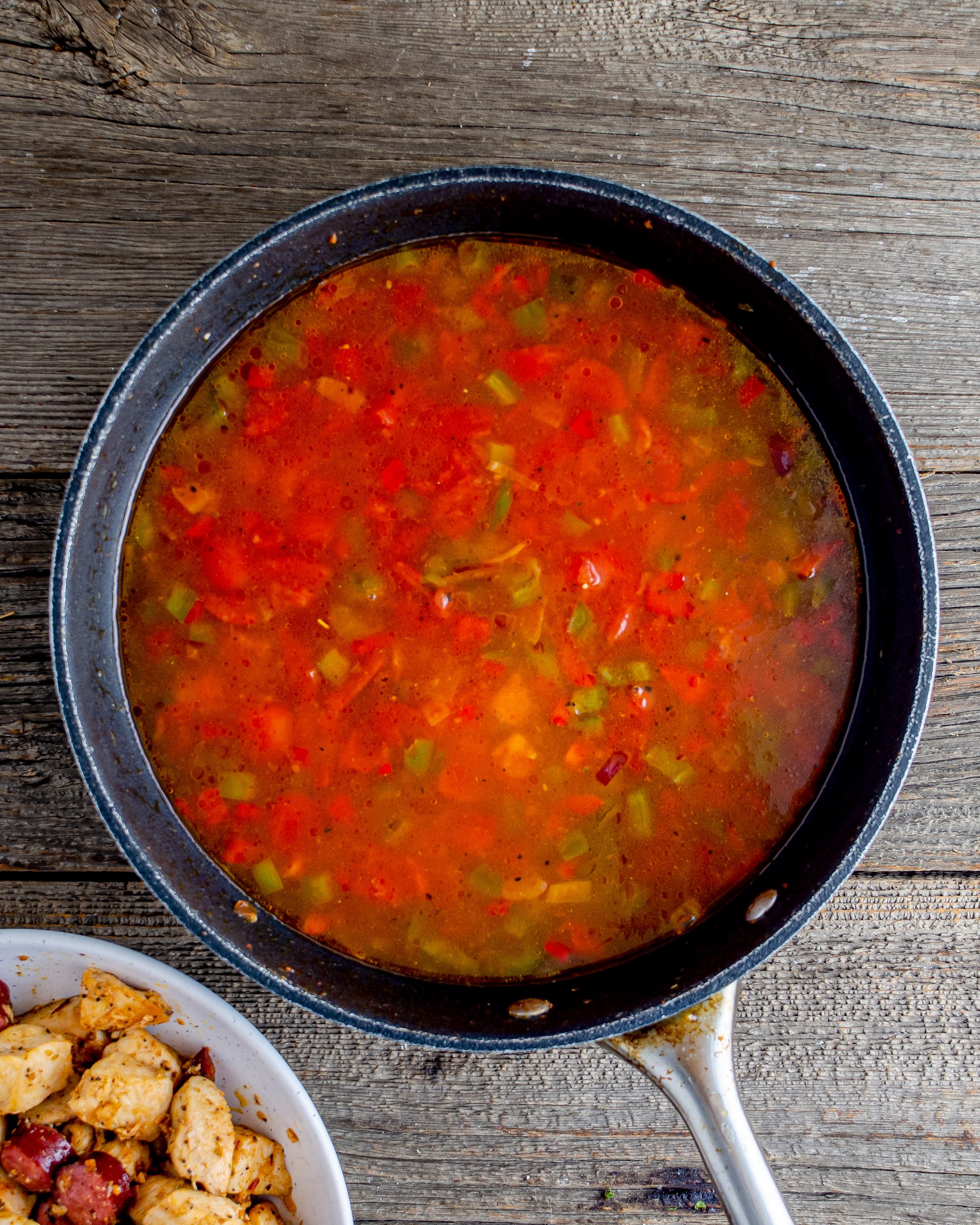 Pour the chicken broth and tomatoes into the skillet, and stir to combine.