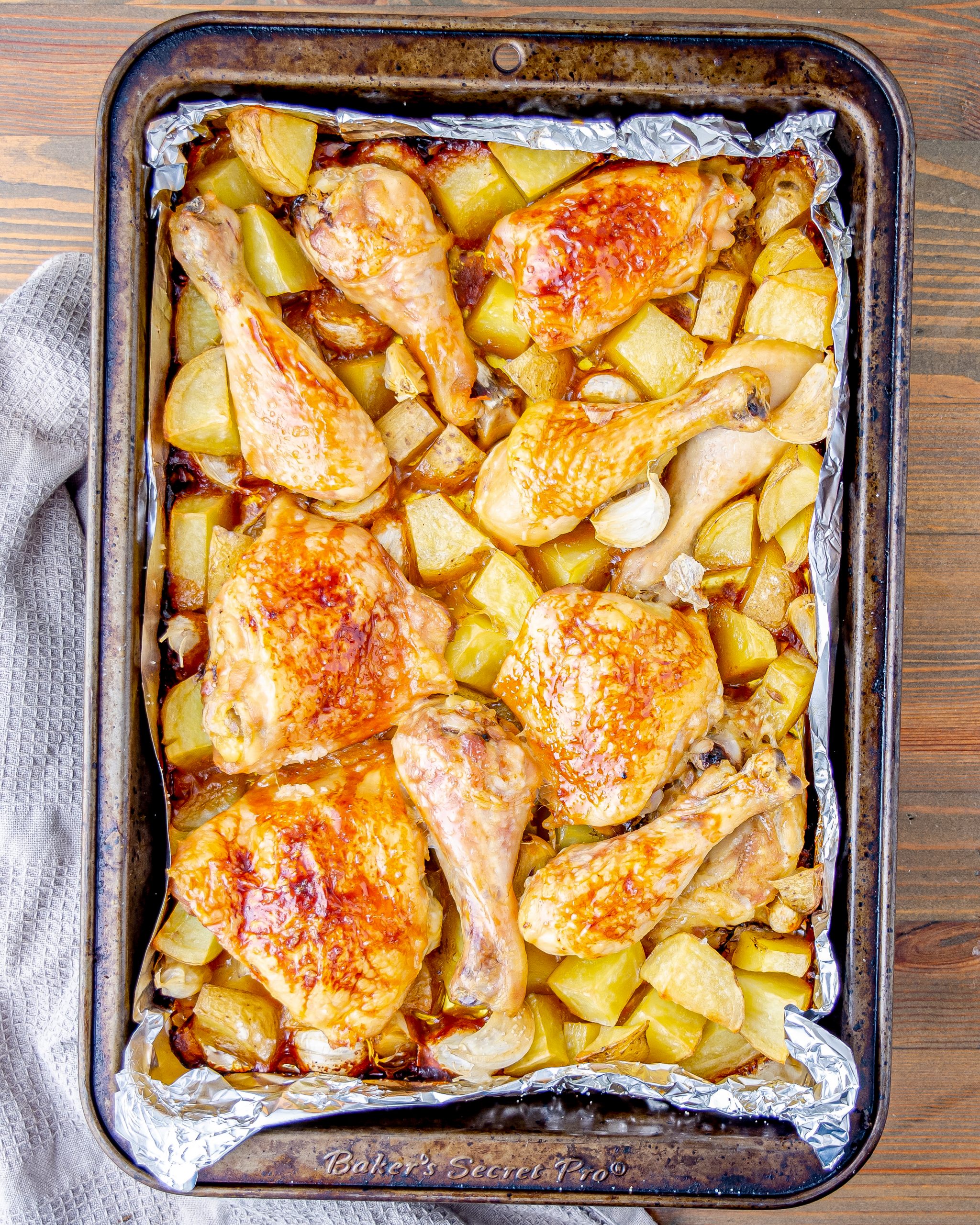 Remove the dish from the oven, and brush the chicken with maple syrup.