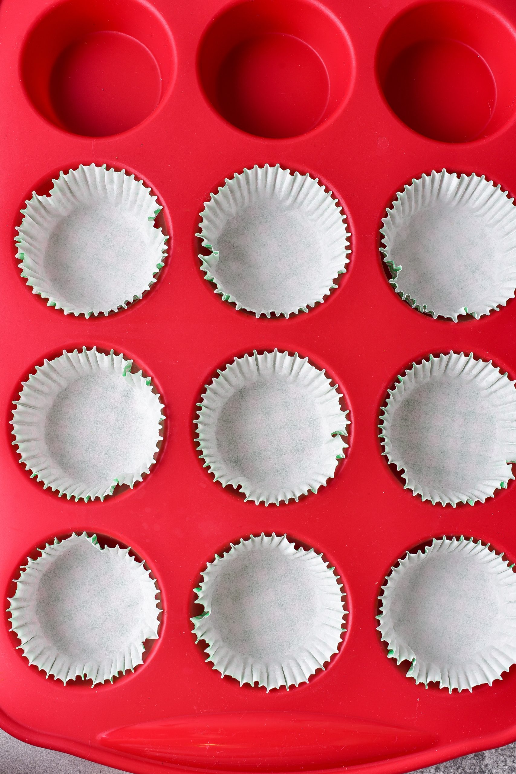 line the sections of a muffin tin with cupcake liners.