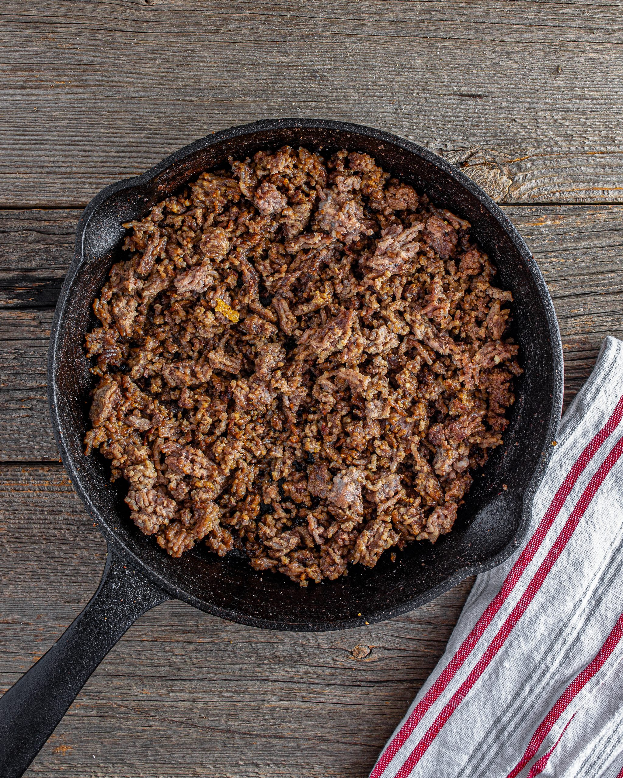 Add the ground beef to a large cast iron skillet and brown until a deep brown crust appears before breaking the beef apart.