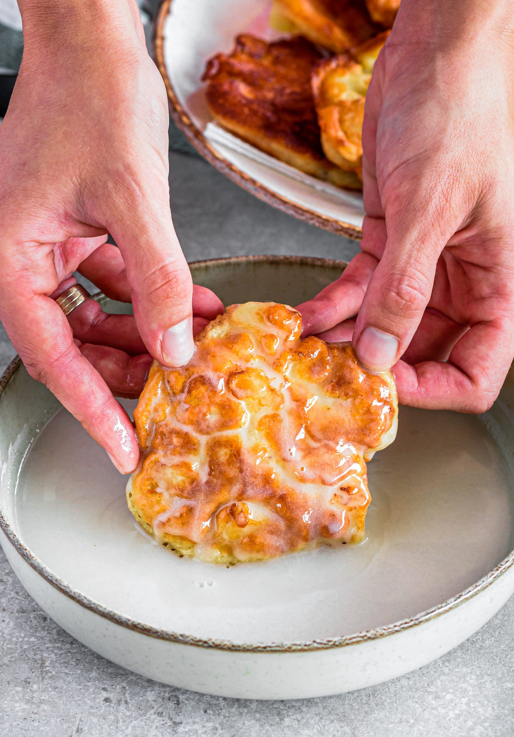 Dip the fritters into the glaze.