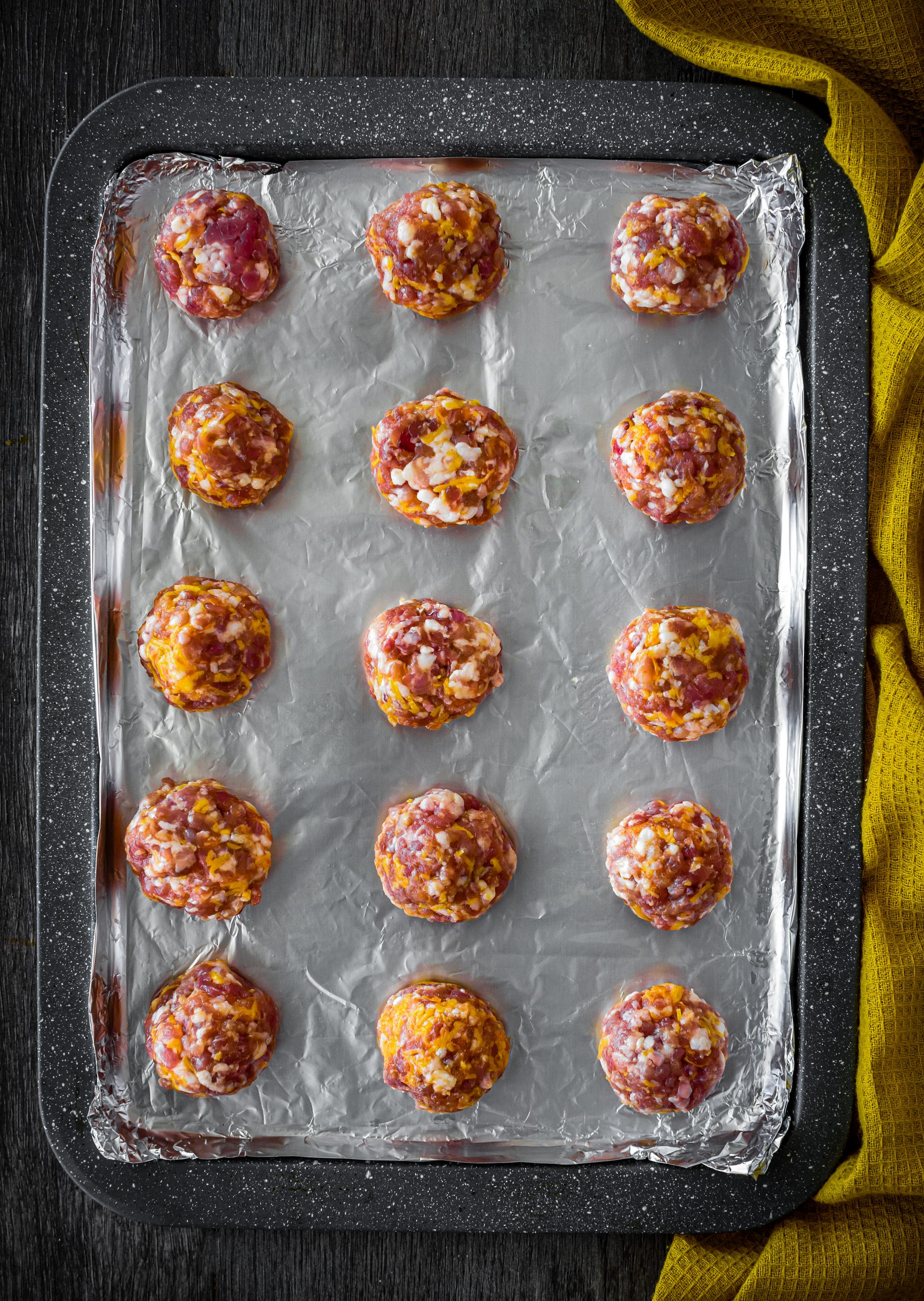 Form the mixture into evenly-sized meatballs, and place onto a parchment-lined baking sheet.