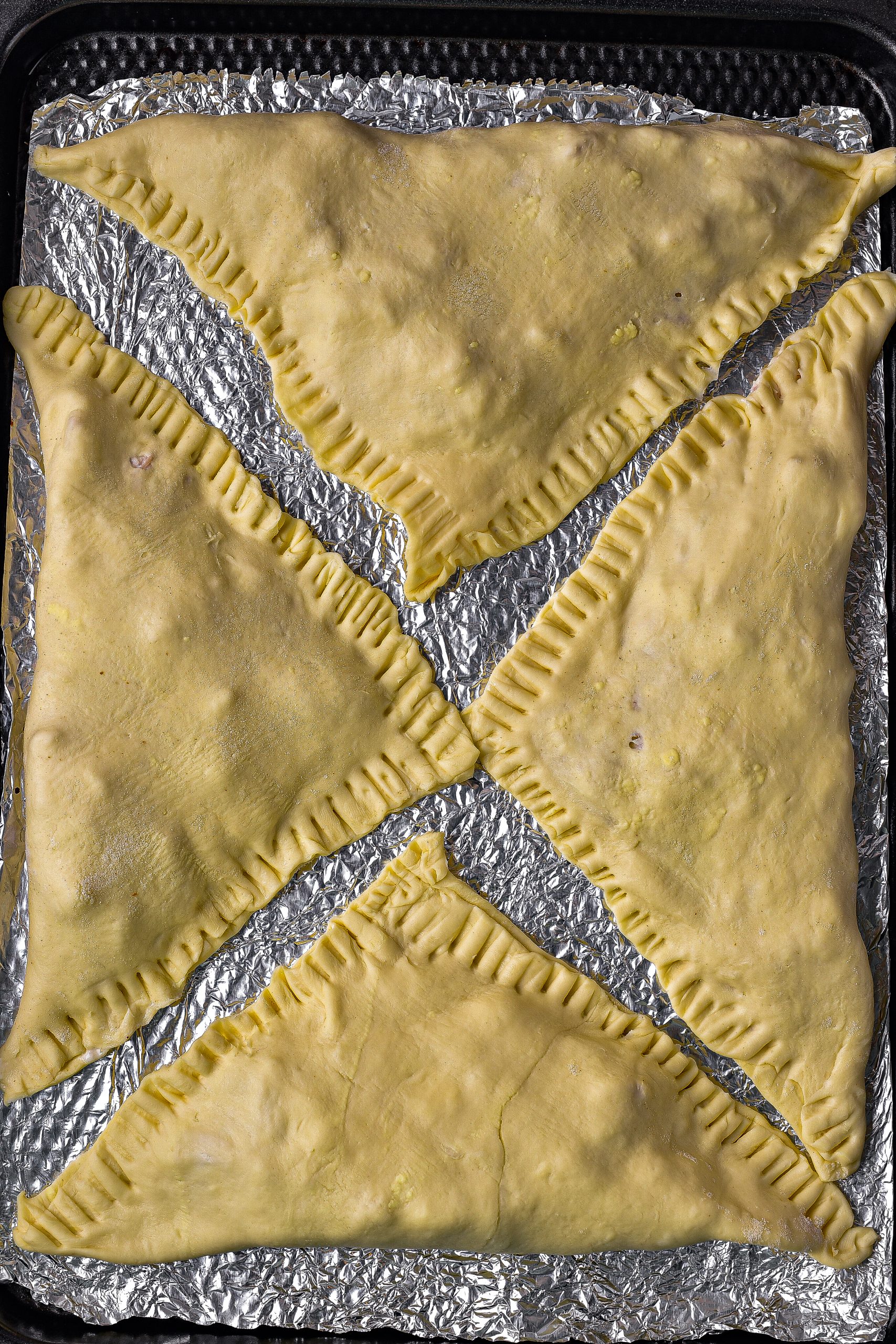 Brush the edges of each puff pastry square with some water, and fold one corner of each square over to the other to form triangles. 